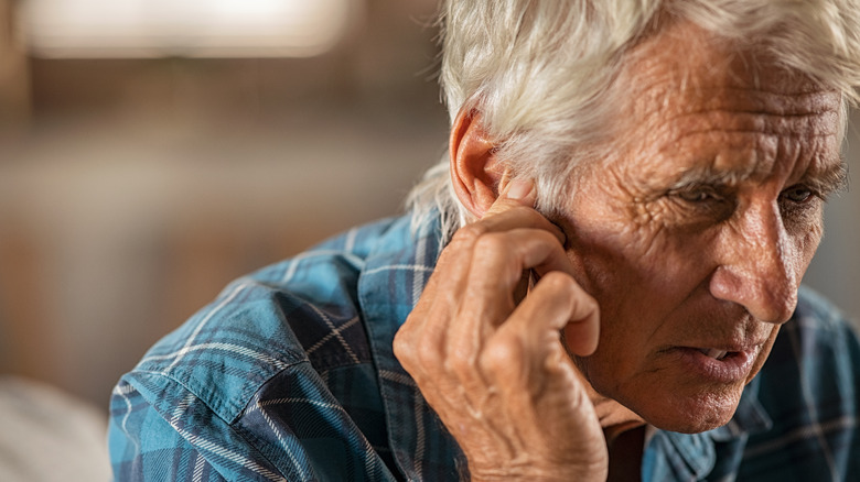 Man holding ear in pain