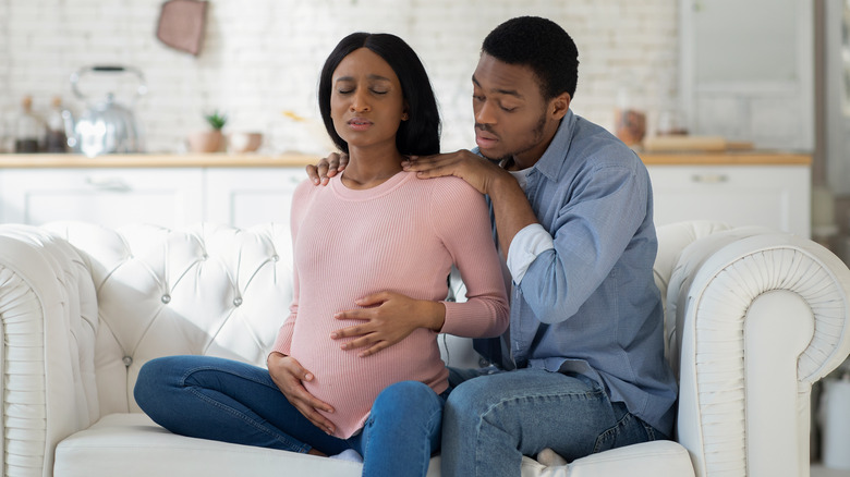 husband comforts pregnant wife during contractions 