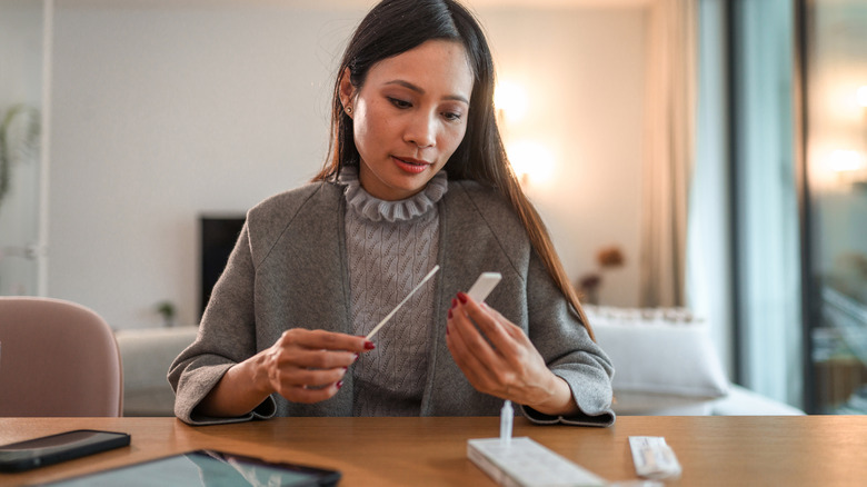 woman holding rapid antigen home test