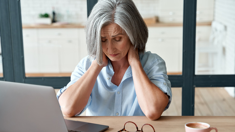 woman holding her neck in pain