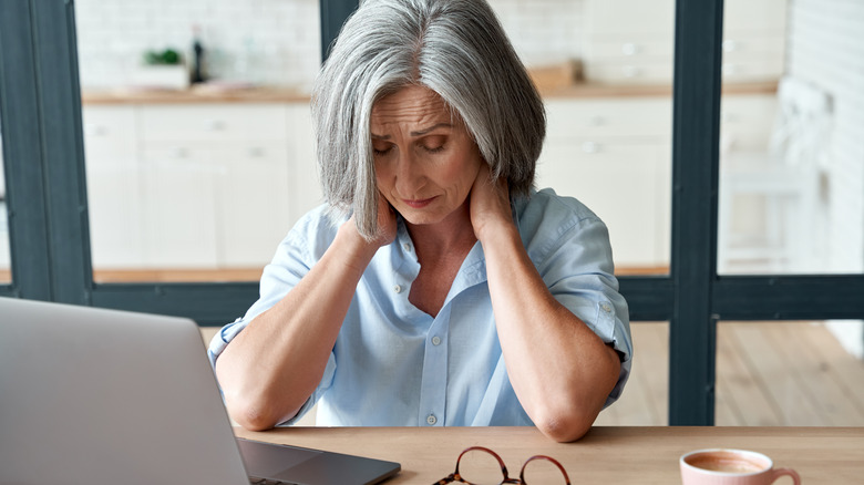 woman holding her neck in pain