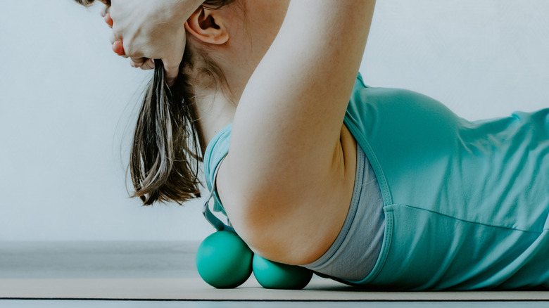 woman using myofascial balls on upper back
