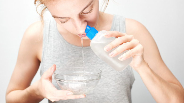 Woman having a saline nasal rinse