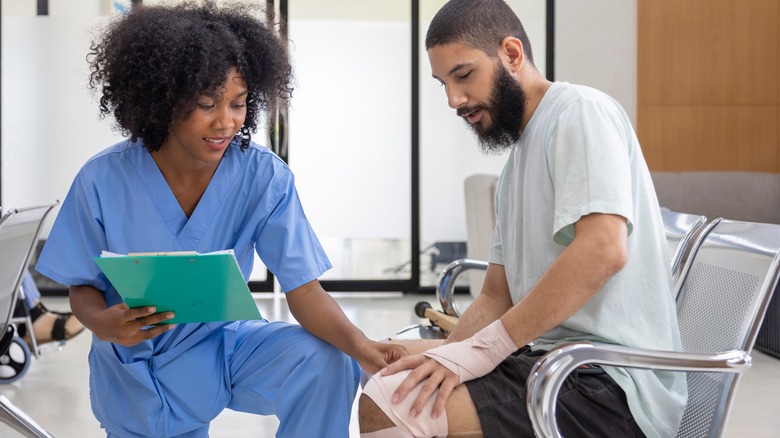 nurse tending to a man who has tendinitis in his knee