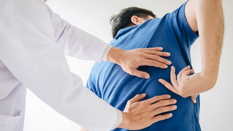 doctor examining back pain patient