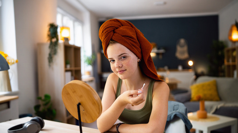 woman holding Q-tip