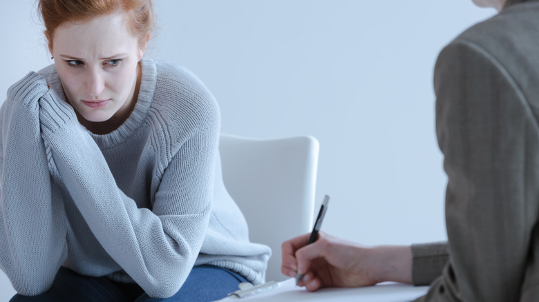 upset young woman meeting with her therapist