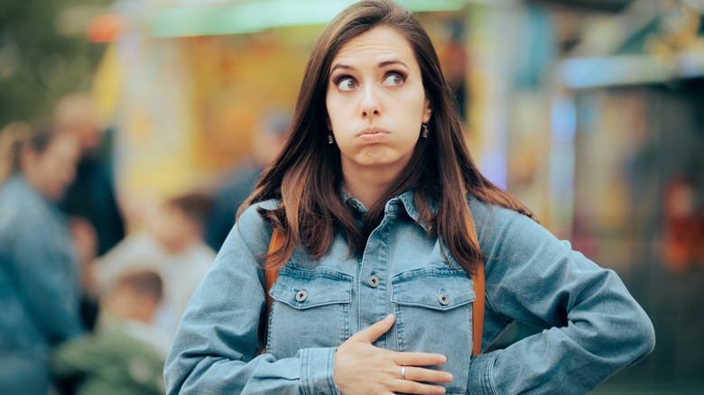 Wincing woman holding stomach 