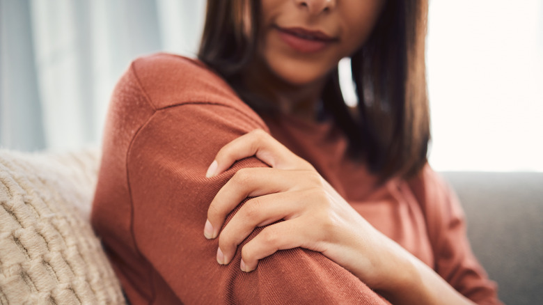 Woman clutching upper arm