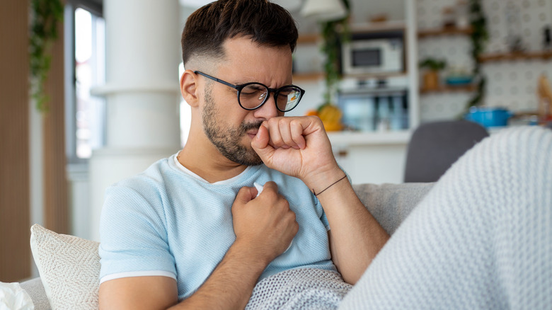 man with chest pain on couch