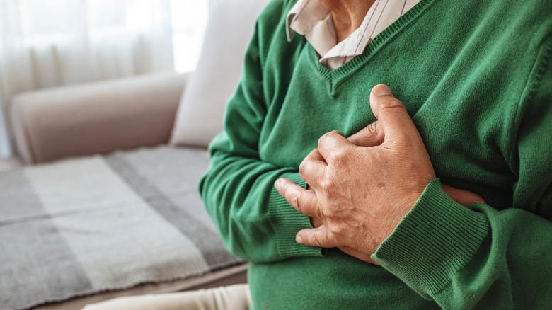 man holding his chest in pain