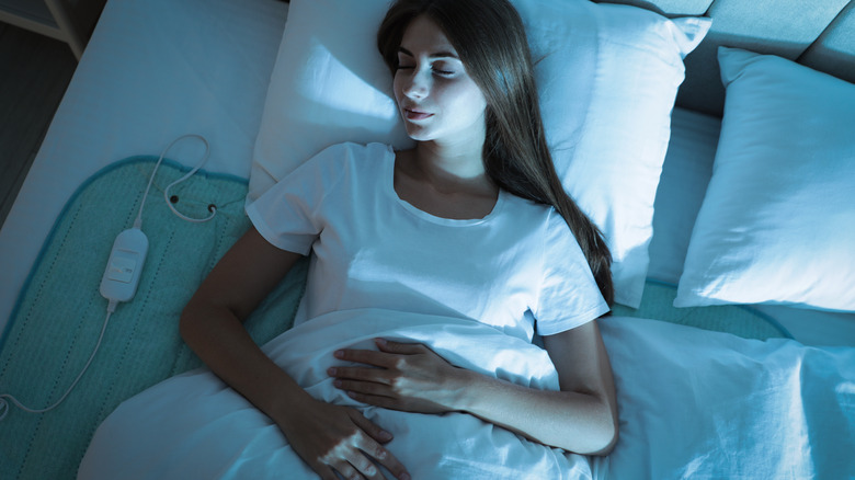 Woman sleeping on heating pad