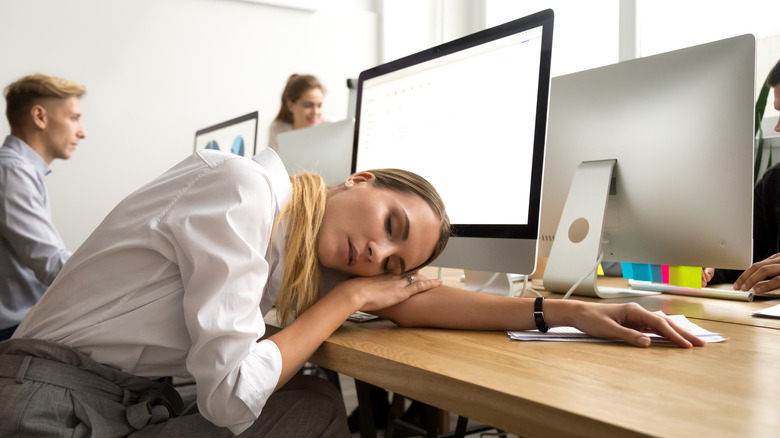 woman sleeping at computer desk