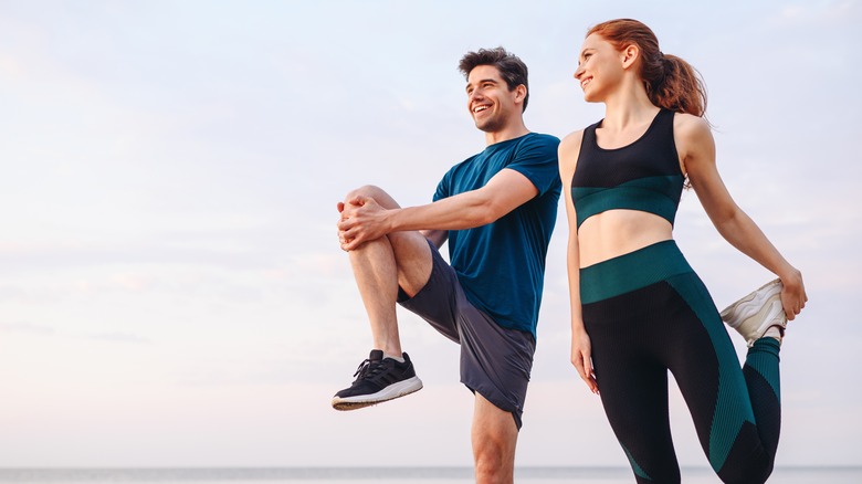 Man and woman stretching before a run