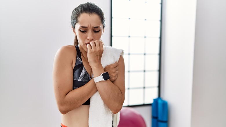 Woman biting nails at gym