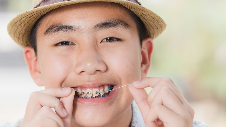 Boy flossing braces