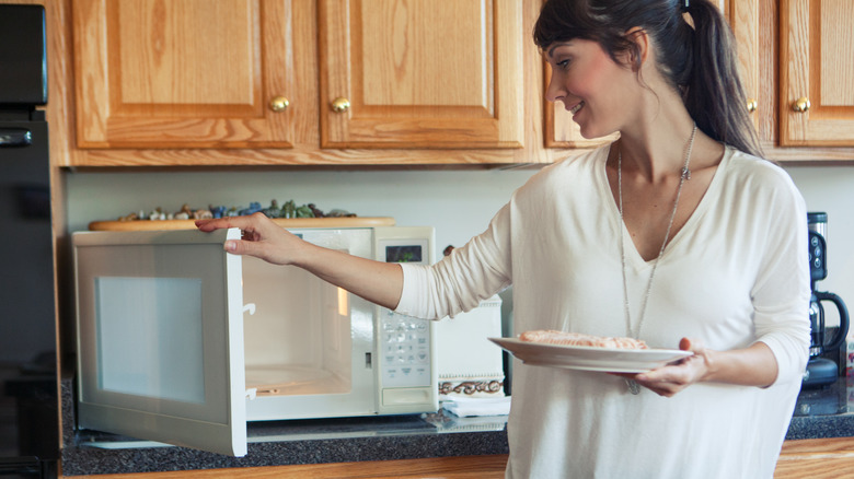 Woman using microwave at home