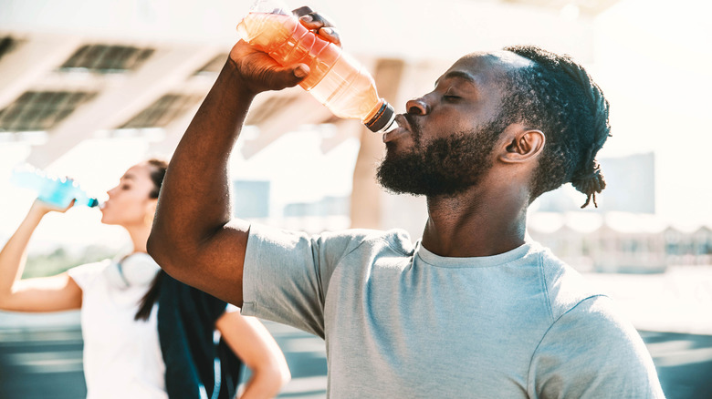 man drinking electrolyte drink