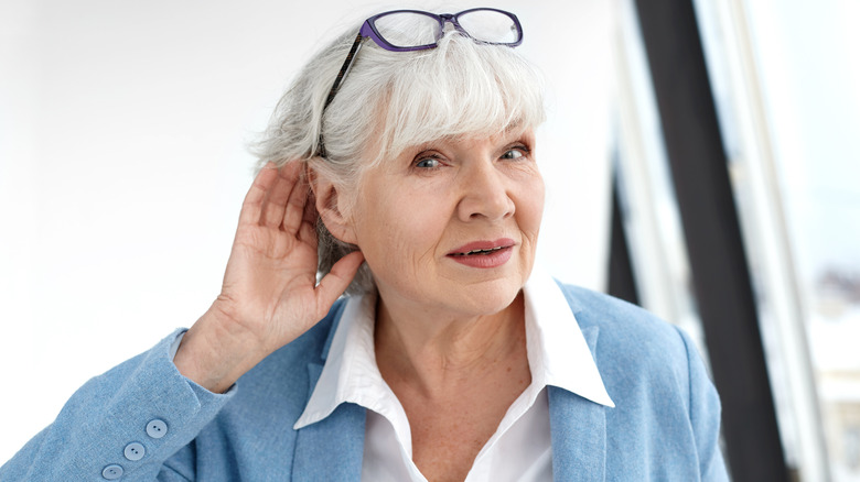 woman with hand up to ear