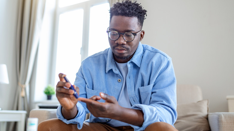 man checking blood sugar