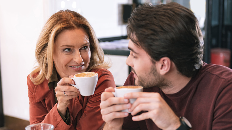 man and woman sipping coffee in a cafe