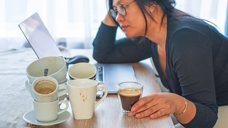Woman drinking coffee at desk
