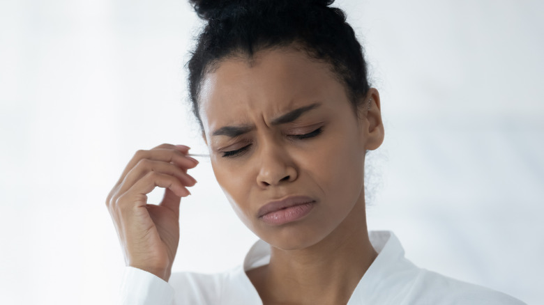 african american girl trying to remove earwax