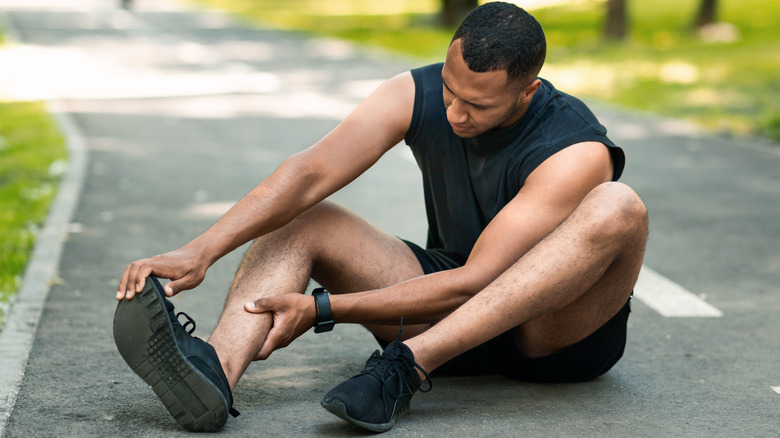 Man holding foot in discomfort