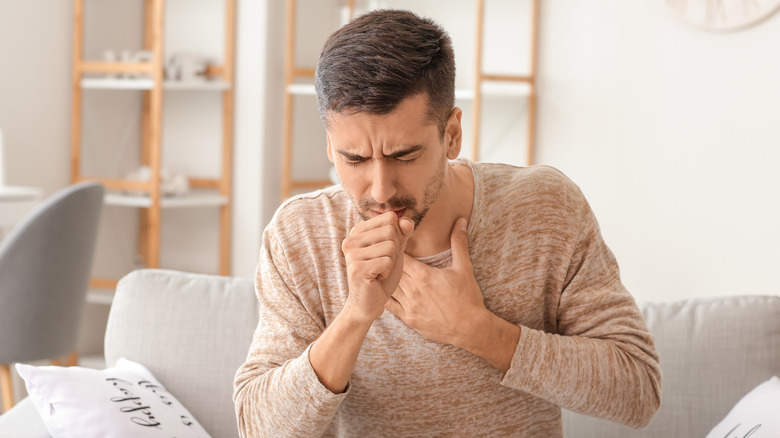 A man coughs in his hand