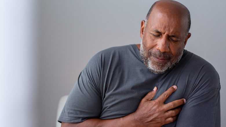 Man clutching heart in pain