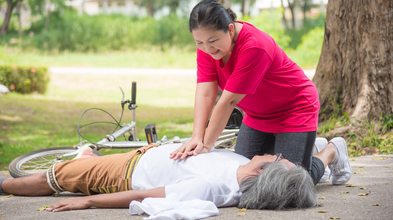 Woman administering CPR to unconscious person