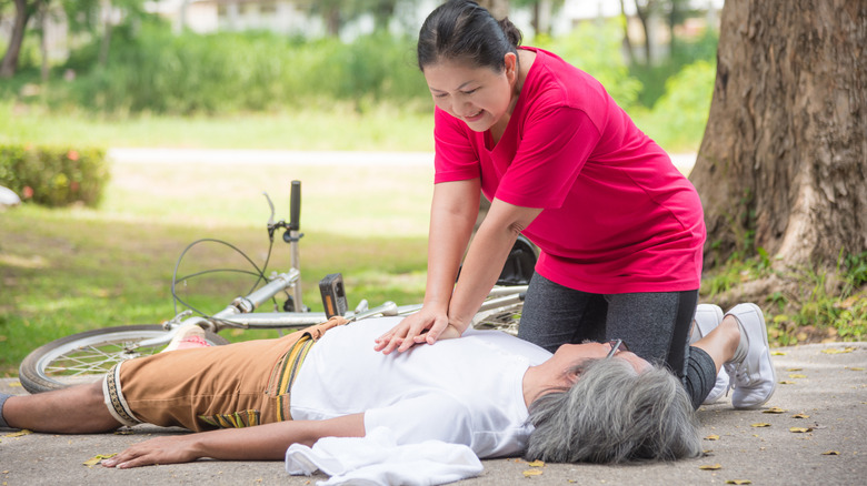 Woman administering CPR to unconscious person