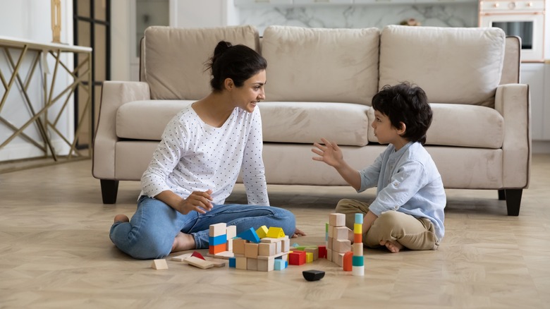 Parent sitting on floor talking with child