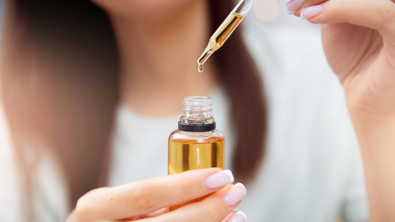 woman holding bottle of essential oils