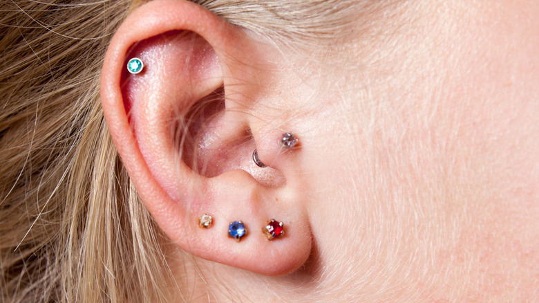 Close up of ear with multiple piercings