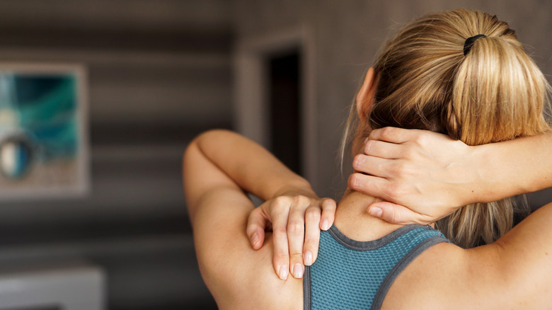 Woman touching back of neck