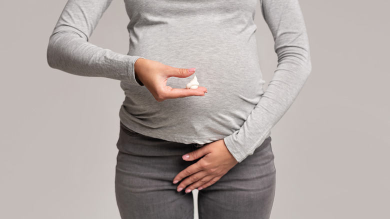 Pregnant woman covering genital area