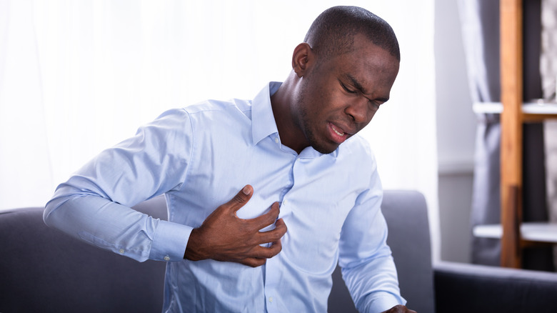 Man with hand on chest in pain