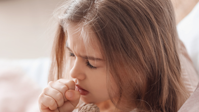 Little girl sick in bed with a cough