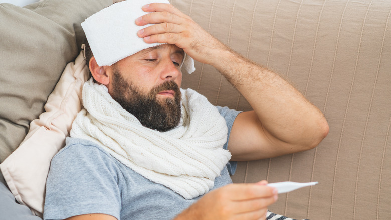 bearded man looking at thermometer