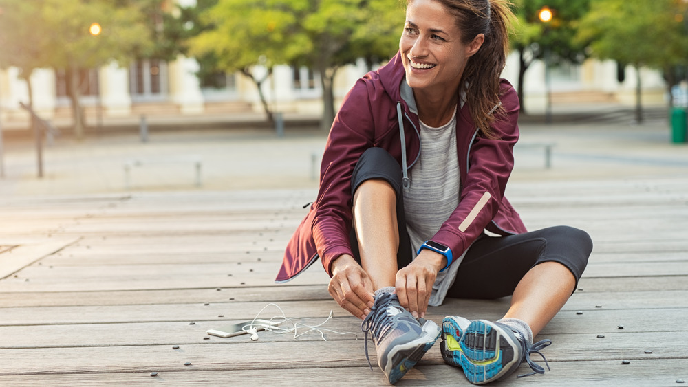 woman runner tying shoes