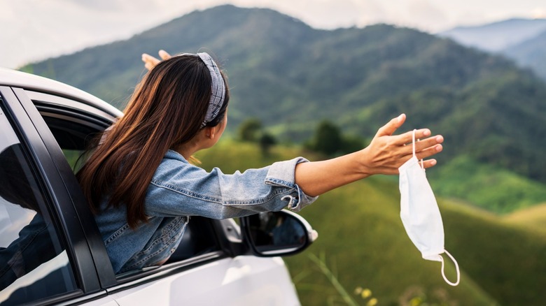 woman removes mask traveling