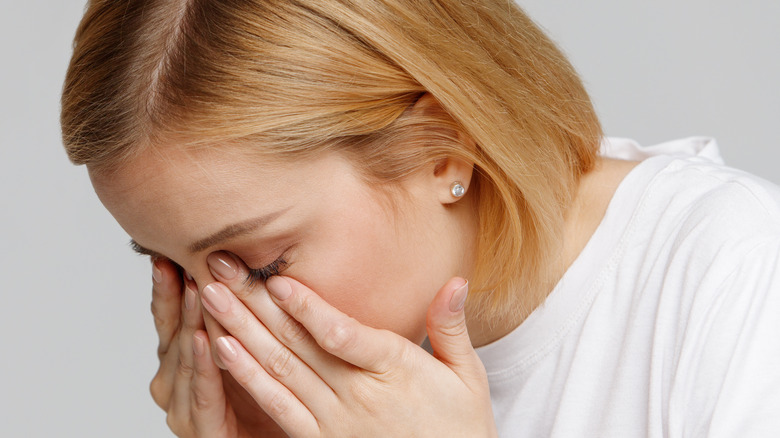 Woman touching inner eye corners