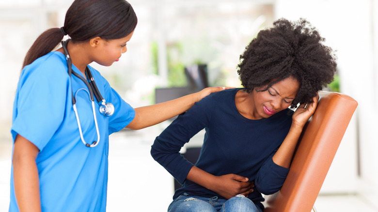 Nurse tending to patient with stomach pain
