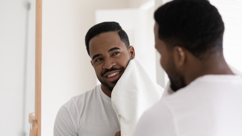 Man wiping face with towel
