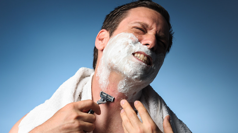 Man grimacing while shaving