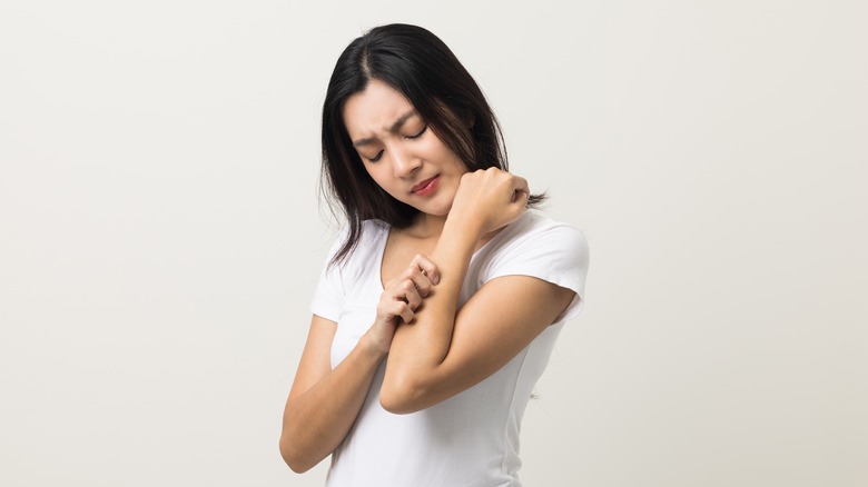 Woman scratching an itchy arm