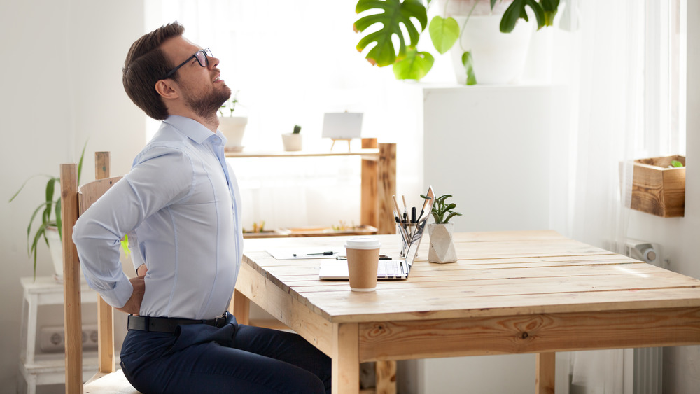 man at kitchen table back pain