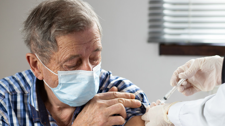 elderly man getting COVID-19 vaccination