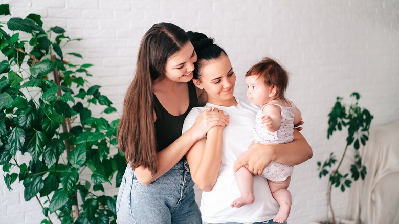 two women smiling at their baby 